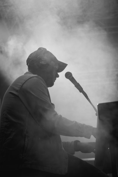 Silhouette eines Pianisten, der in einem Nebel von der Seite spielt und singt.